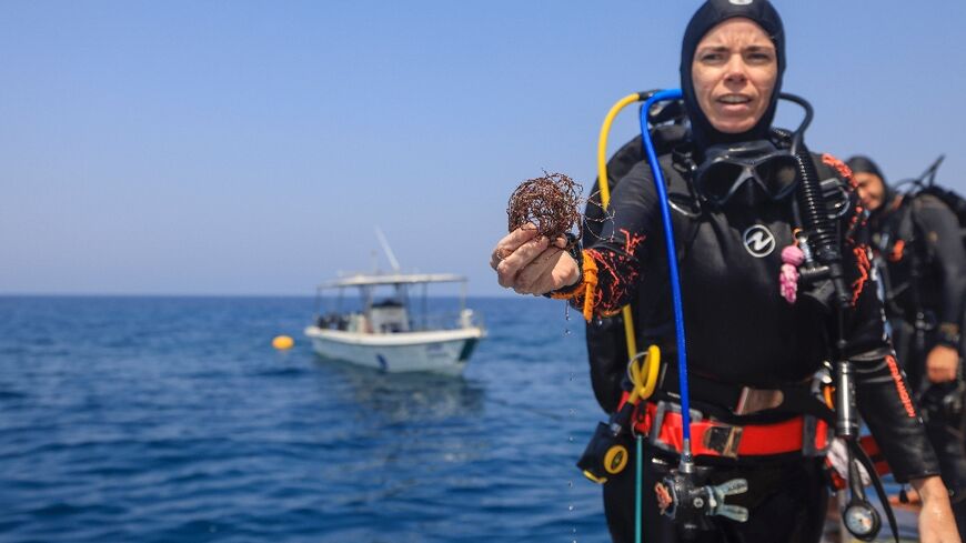 A volunteer diver shows fishing nets removed from coral reefs at Oman's Dimaniyat islands