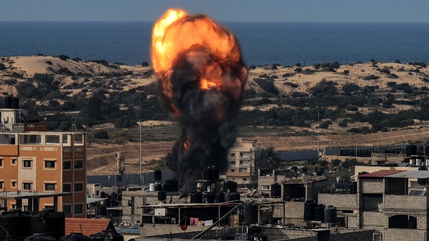A ball of fire rises above a building during an Israeli strike in Rafah