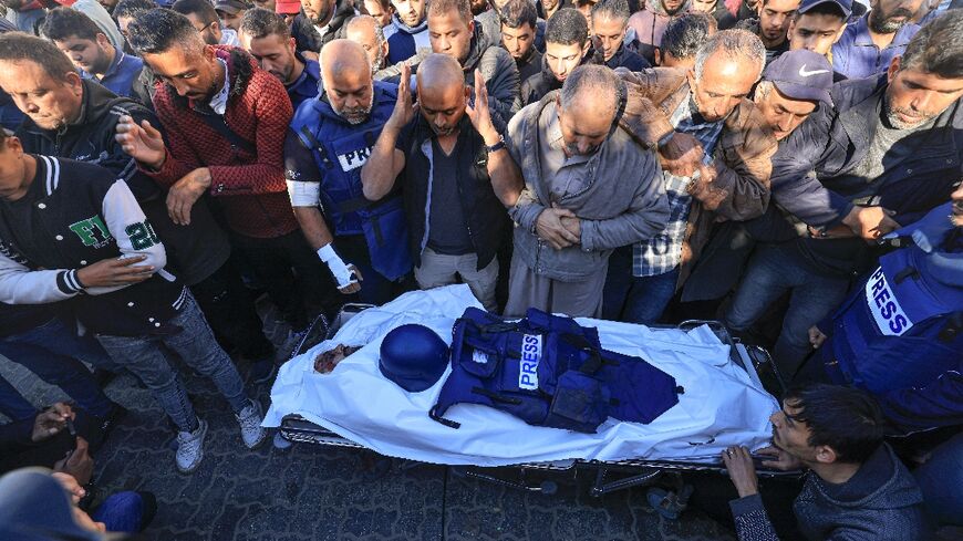 Colleagues and family members pray over the body of Al Jazeera cameraman Samer Abu Daqqa, who was killed during Israeli bombardment