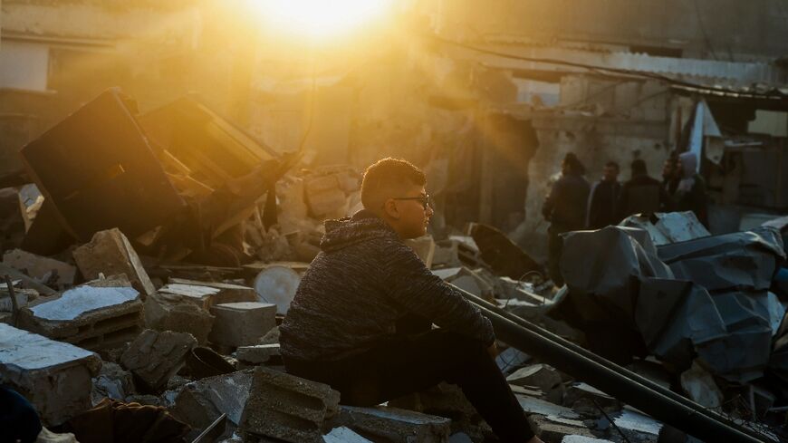 A Palestinian boy sits on the rubble of a building destroyed by bombardment in Rafah