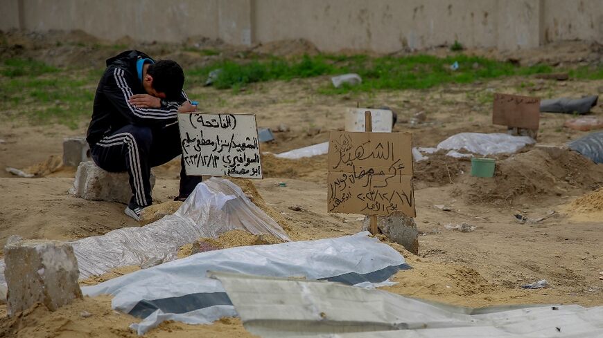 Graves and bodies at a makeshift cemetery near Gaza City's al-Shabiyah district 