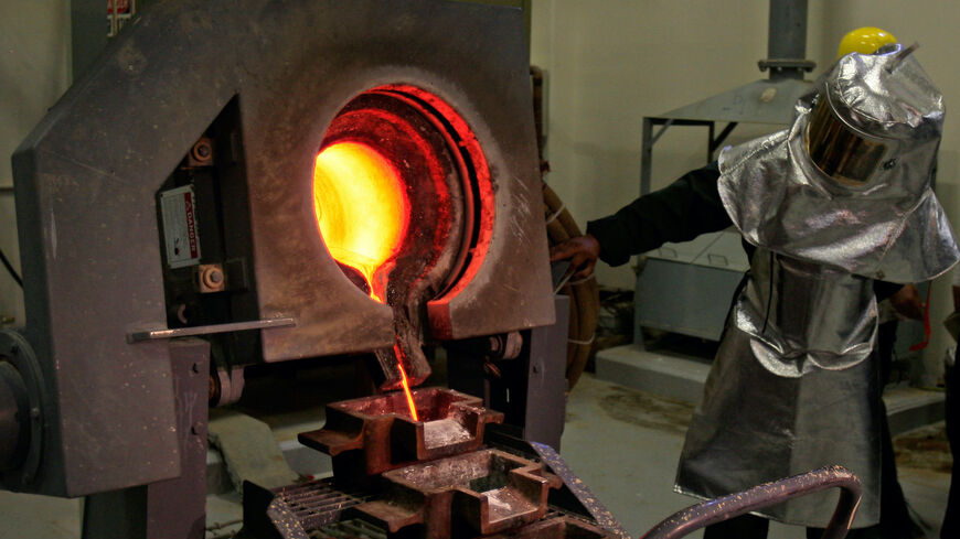 A Saudi mine worker pours a stream of molten gold from the furnace into moulds to produce gold ingots during a press tour at the Al-Amar Gold Mine, 195kms southwest of the Saudi capital Riyadh, on May 28, 2008.