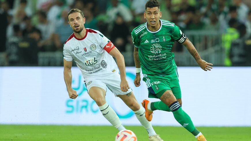 Jordan Henderson of Al Ettifaq and Roberto Firmino of Al Ahli battling for the ball during the Saudi Pro League match.