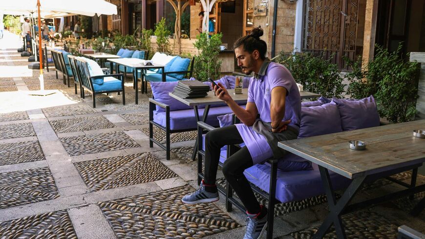 A staff waits for costumers at a restaurant in Lebanon's coastal historical city of Byblos, on Nov. 10, 2023. 