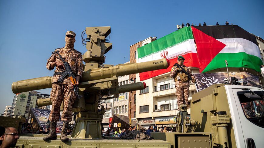Two Islamic Revolutionary Guard Corps (IRGC) armed military personnel are monitoring an area while standing guard next to an Iranian Majid anti-aircraft missile system during the Ela Beit Al-Moghaddas (Al-Aqsa Mosque) military rally in Tehran, Iran. 