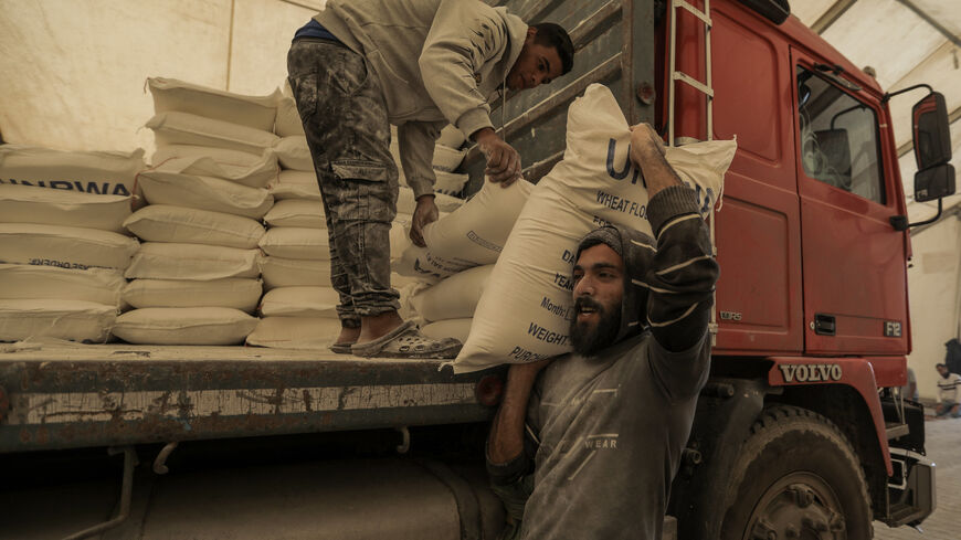 KHAN YUNIS, GAZA - NOVEMBER 22: UNRWA distributes flour to Palestinian refugees on November 22, 2023 in Khan Yunis, Gaza. On Tuesday night, Israel and Hamas agreed to a four-day pause in fighting that would entail the release of 50 hostages, as well as the release of 150 Palestinian prisoners. But the start of the short-term truce had not been confirmed as of Wednesday morning and air strikes continued in the territory overnight.