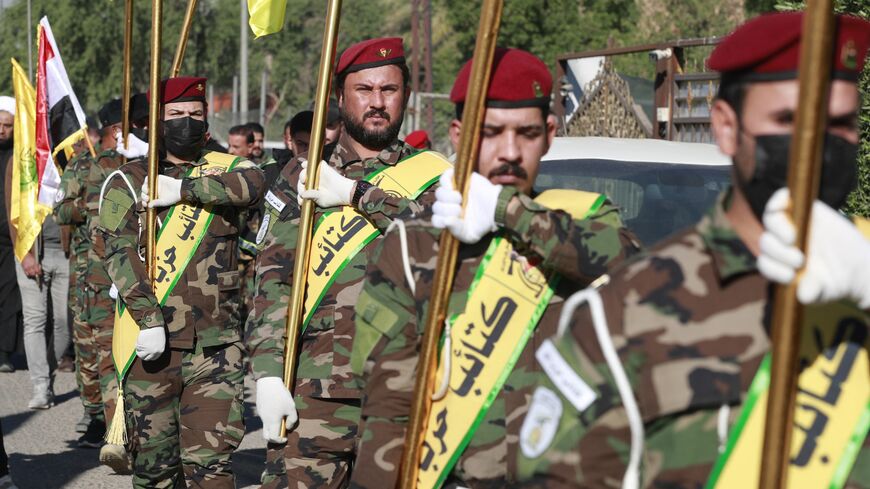 Fighters lift flags of Iraq and paramilitary groups, including al-Nujaba and Kataib Hezbollah.