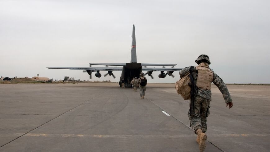 A soldier loads up onto an American plane near Mosul, Iraq.