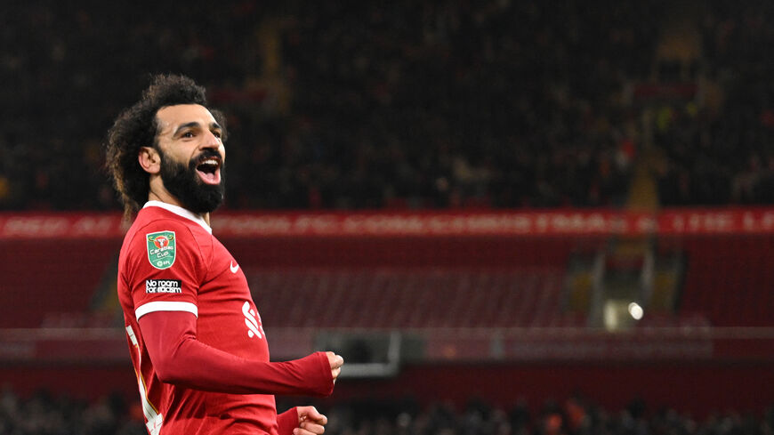 Liverpool's Egyptian striker #11 Mohamed Salah celebrates after scoring his team fourth goal during the English League Cup quarter-final football match between Liverpool and West Ham United at Anfield in Liverpool, north west England on December 20, 2023. (Photo by Oli SCARFF / AFP) / RESTRICTED TO EDITORIAL USE. No use with unauthorized audio, video, data, fixture lists, club/league logos or 'live' services. Online in-match use limited to 120 images. An additional 40 images may be used in extra time. No vi