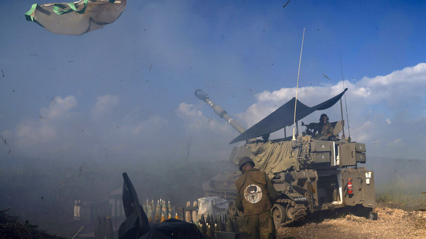 TOPSHOT - An Israeli soldier wearing a patch on the back of his flack jacket showing Lebanon's Hezbollah leader Hassan Nasrallah as a target, stands in front of a self-propelled artillery howitzer in Upper Galilee in northern Israel, as an artillery unit shells southern Lebanon on January 4, 2024. Nasrallah warned Israel against all-out conflict, after Israeli army chief Herzi Halevi, in a visit to the Lebanese border, said troops were "in very high readiness". (Photo by jalaa marey / AFP) (Photo by JALAA M