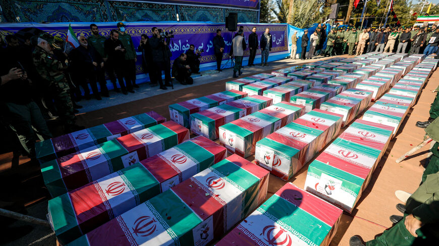 Iranian mourners gather around coffins wrapped with the Iranian flags during the funeral ceremony of yesterday's explosion on Jan. 5, 2024, in Kerman, Iran.