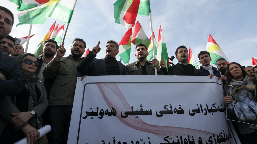 Protesters hold a banner and Kurdish flags during a demonstration outside the United Nations (UN) office, a day after several areas in the city were hit by a missile attack launched by Iran's Islamic Revolutionary Guard Corps (IRGC), in Erbil, the capital of Iraq's northern autonomous Kurdish region early on Jan. 16, 2024. 
