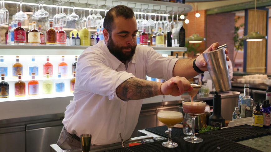 Lebanese bartender Hadi Ghassan prepares a drink behind the counter at "Meraki Riyadh", a pop-up bar offering non-alcoholic bellinis and spritzes, served in chilled cocktail glasses, in Riyadh on January 23, 2024. The bar's success highlights widening acceptance of more daring non-alcoholic fare even as booze itself remains strictly off-limits in the Gulf kingdom, home to Islam's holiest sites. (Photo by Fayez Nureldine / AFP) (Photo by FAYEZ NURELDINE/AFP via Getty Images)