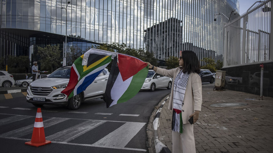 A pro Palestinian activist waves Palestinian and South African flags as she demonstrates following the International Court of Justice (ICJ) ruling of the case against Israel brought by South Africa in The Hague at the U.S. Consulate in Johannesburg on January 26, 2024. South African lawyers presented their case at the UN's top court in The Hague, where South Africa lodged an urgent appeal to force Israel to "immediately suspend" its military operations in Gaza. The International Court of Justice (ICJ) ruled