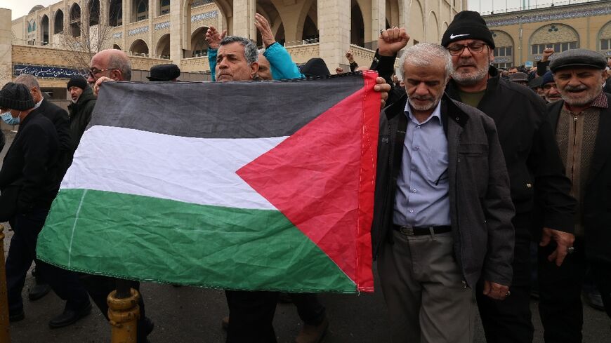 Iranians with a Palestinian flag demonstrate in support of Yemen and Palestinians after Friday prayers in Tehran