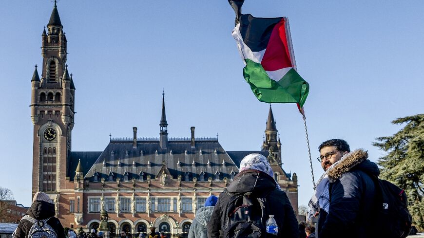 A demonstrator waves the Palestinian flag in front of the Peace Palace ahead of the ICJ verdict