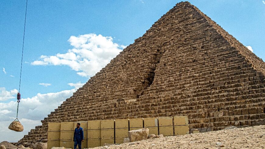 A stone is lifted into place during controversial restoration work on the Menkaure Pyramid in Giza, which has now been paused by the Egyptian government, pending the findings of a review panel