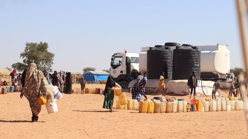 Refugees fleeing the conflict in Sudan queue to collect drinking water from the Doctors Without Borders (MSF) distribution point at Ourang refugee camp in Adre, Chad on December 7, 2023