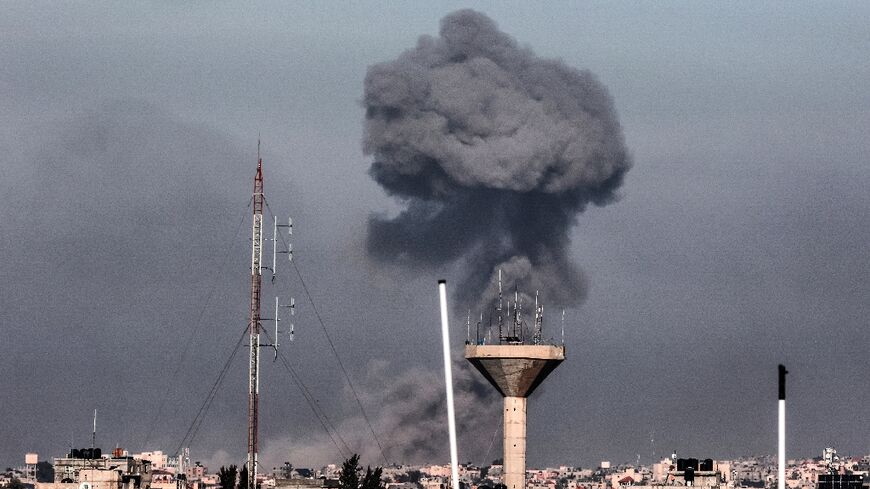 This picture taken from Rafah, in the southern Gaza Strip, shows smoke rising over buildings in Khan Yunis during Israeli bombardment on February 8, 2024