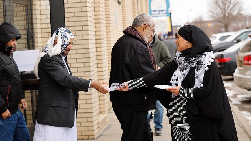 Samra'a Luqman hands out fliers outside of a mosque in Dearborn, Michigan, asking voters not to vote for President Joe Biden