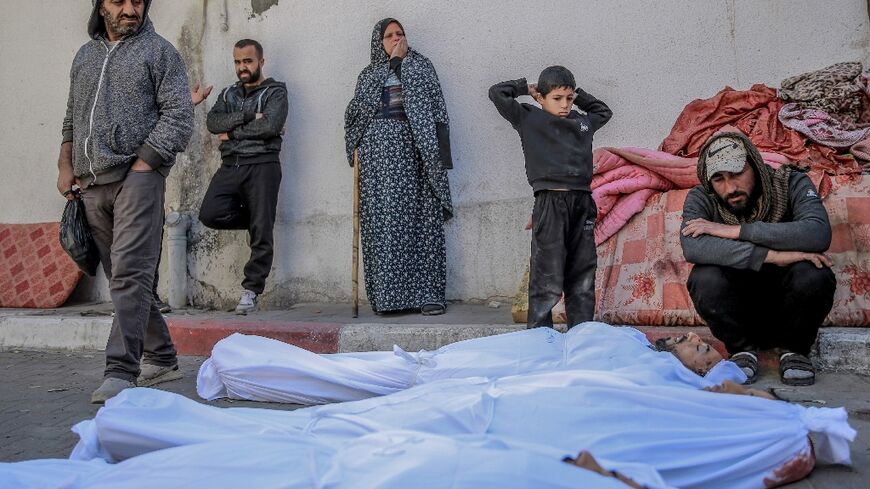 People at Al-Shifa hospital in Gaza City mourn over the bodies of Palestinians killed when people rushed toward aid trucks