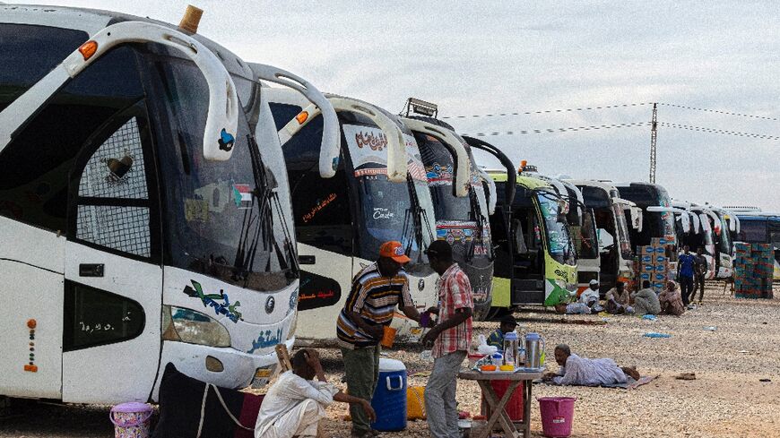 Sudanese drivers rest on May 14, 2023 after transporting evacuees from Sudan into Egypt, in Wadi Karkar village near Aswan 