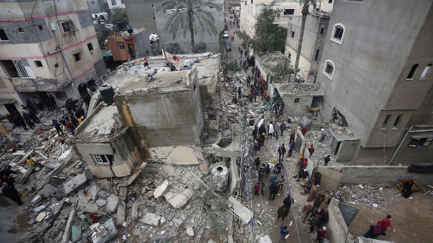 People search for victims in the rubble of the Baraka family home in Deir al-Balah in the central Gaza Strip after it was hit in an Israeli air strike