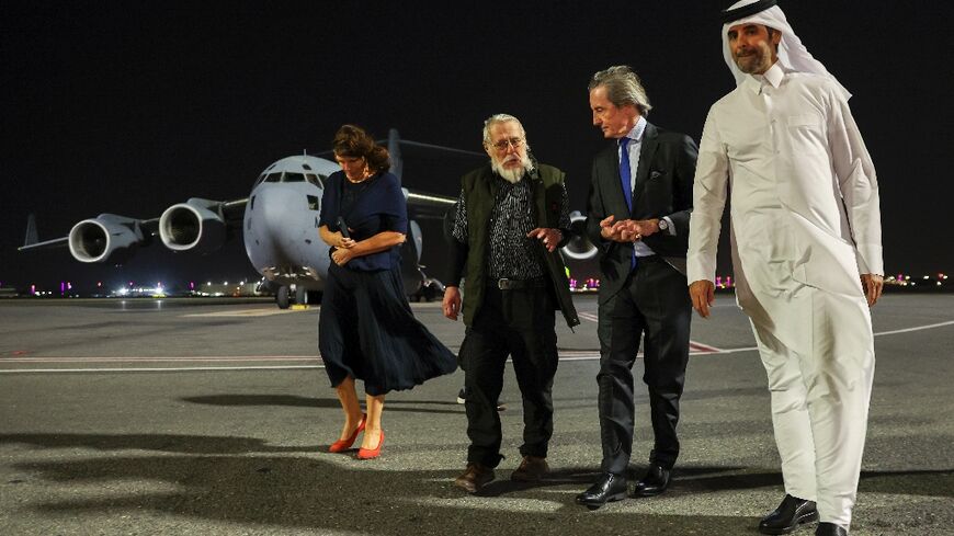 Austrian far-right extremist Herbert Fitz (2nd-L) with officials on the tarmac at Doha international airport following his release from detention in Afghanistan