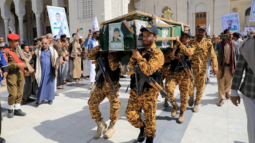 Huthi fighters act as pallbearers at the funerals in Sanaa of 17 of their comrades the Yemeni rebel group says were killed in US air strikes earlier this week