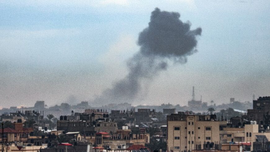 A plume of smoke is seen rising over Khan Yunis from nearby Rafah in the southern Gaza Strip