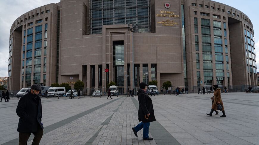 People walk past the Caglayan Justice Palace courthouse in Istanbul on March 21, 2022. - Turkey's leading activist Osman Kavala, who at the weekend marked his 1,600th day in prison without conviction, will appear in court on March 21, 2022, in a case that has strained Ankara's ties with the West. Kavala attends the court hearing via video link from his prison. 