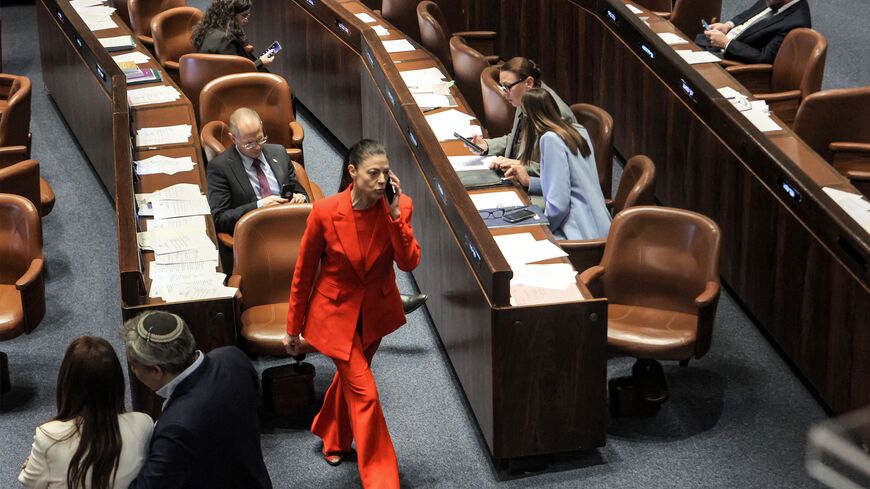 Merav Michaeli (C), leader of Israel's Labour party and member of Knesset (parliament), speaks on the phone during a Knesset session in a red costume as a form of protest alluding to "The Handmaid's Tale" book and television series, in Jerusalem on March 15, 2023. (Photo by GIL COHEN-MAGEN / AFP) (Photo by GIL COHEN-MAGEN/AFP via Getty Images)
