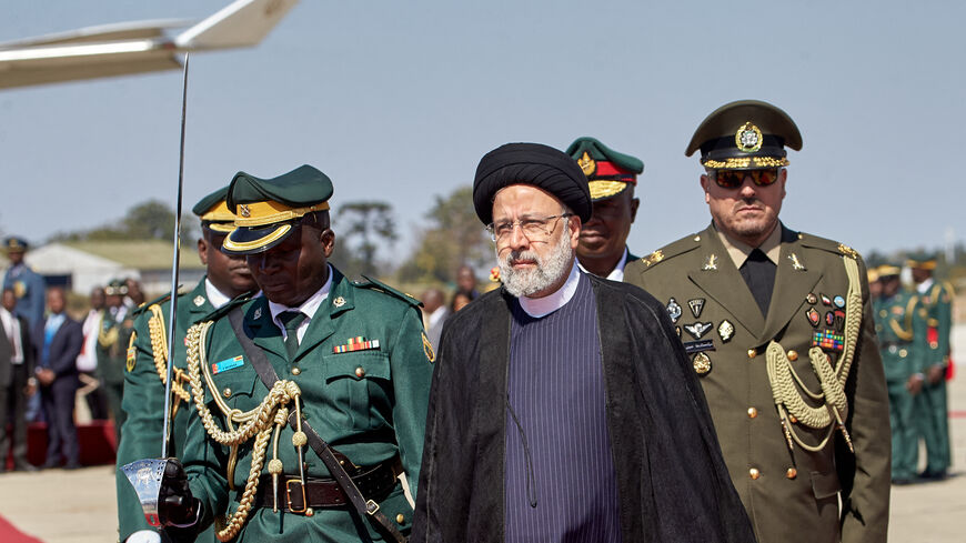 Iranian President Ebrahim Raisi (C) inspects the guard of honour upon his arrival for a state visit at the Robert Gabriel Mugabe International Airport in Harare on July 13, 2023. (Photo by Jekesai NJIKIZANA / AFP) (Photo by JEKESAI NJIKIZANA/AFP via Getty Images)
