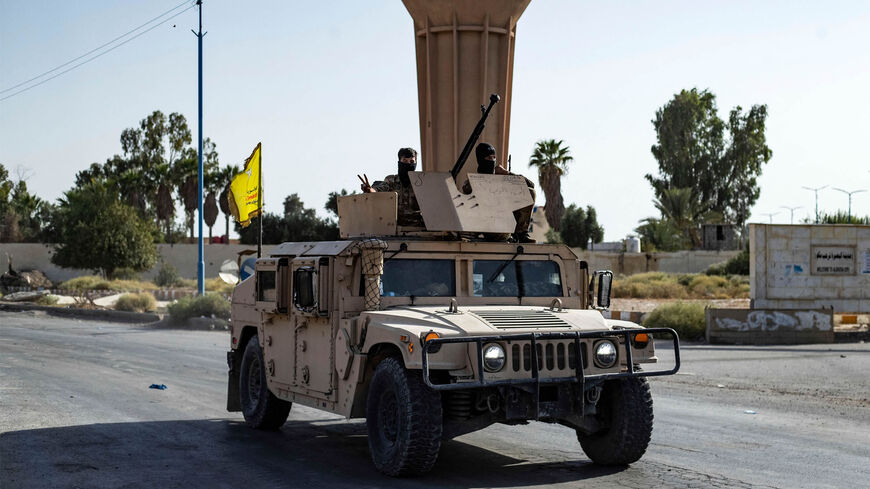 A vehicle of the Syrian Democratic Forces is pictured along a road as fighters deploy to impose a curfew in the town of al-Busayrah during a guided media tour organized by the SDF, in northeastern Deir ez-Zor province, Syria, Sept. 4, 2023.