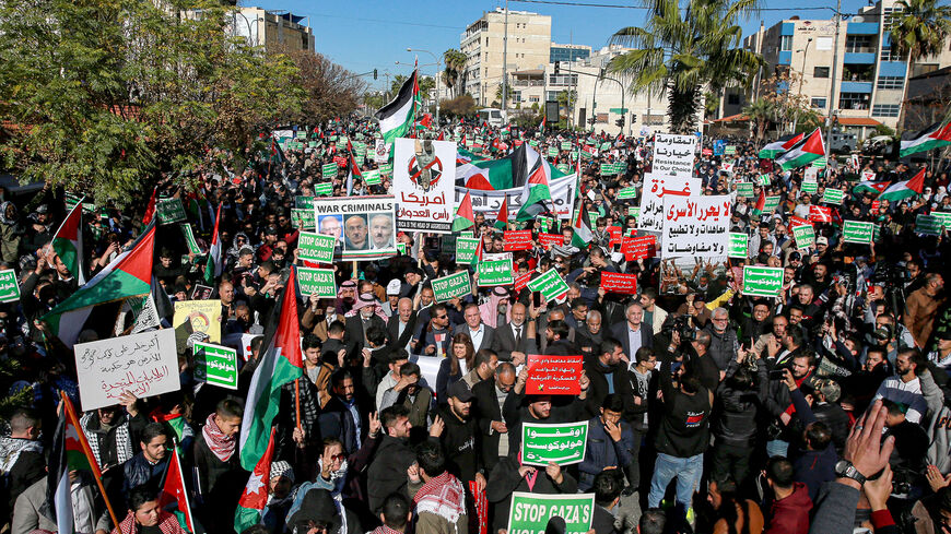 People wave Palestinian and Jordanian flags as they march during a demonstration near the US Embassy in solidarity with the people of Gaza, Amman, Jordan, Dec. 15, 2023.