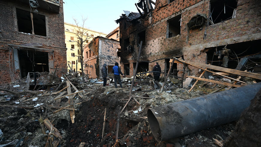 Local residents inspect damages outside an apartment building after the overnight Russian drones attack in Kharkiv, Dec. 31, 2023, amid the Russian invasion of Ukraine. Kyiv said on Dec. 31, 2023, it destroyed 21 of 49 Iranian-made "Shahed" drones fired by Russia overnight, adding that six guided missiles had also targeted the northeastern city of Kharkiv.