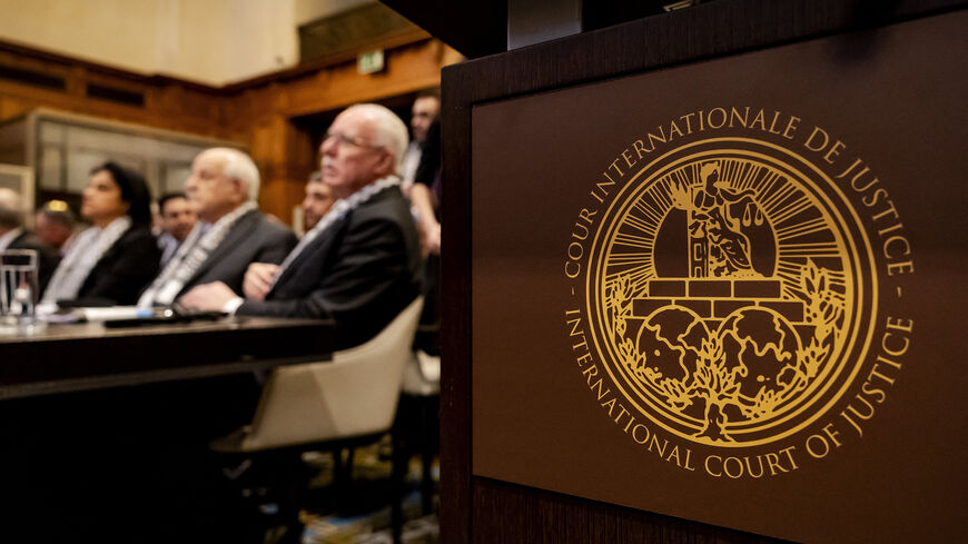 The logo of the International Court of Justice is seen next to Minister of Foreign Affairs of the Palestinian Authority Riyad al-Maliki (R) and members of his delegation, as they listen at the start of a hearing on the legal consequences of the Israeli occupation of the Palestinian territories, The Hague, Netherlands, Feb. 19, 2024.