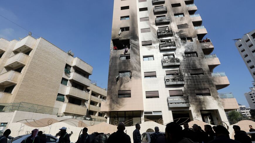 People check the damage on a building reportedly hit in an Israeli air strike in the Kafr Sousa district of the Syrian capital Damascus on February 21, 2024. At least two people were killed on February 21 in an Israeli attack on Damascus, according to the Syrian Observatory for Human Rights and Syrian state media. 