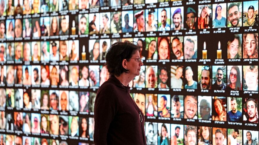 Raquel Ukeles of Israel's national library looks at a screen bearing the portraits of Israelis killed during the October 7 attack