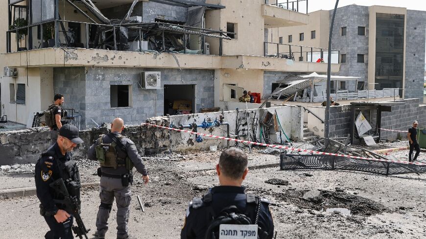 Isreli security forces inspect the area of the border town of Kiryat Shmona where a suspected Hezbollah rocket killed a civilian
