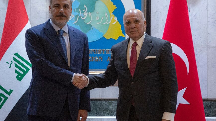 Turkish Foreign Minister Hakan Fidan (L) holds talks with his Iraqi counterpart Fuad Hussein ahead of an expected visit to Baghdad by Turkish President Recep Tayyip Erdogan