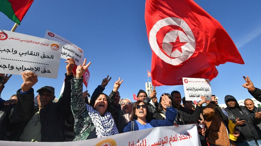 Trade unionists shout slogans as they take to the streets of Tunis to protest against proposed legislation that will grant the government sweeping powers over NGOs