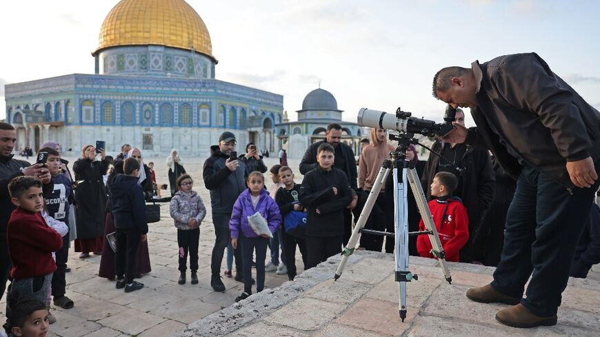 A man uses a telescope to look for the moon to mark the start of the Muslim holy fasting month of Ramadan near the Dome of the Rock at the Al-Aqsa Mosque in the Old City of Jerusalem