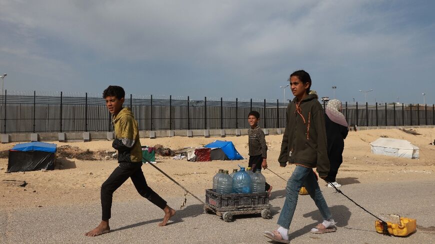 Children in Gaza's Rafah, where Israel has repeatedly threatened to invade, carry water to a displacement camp
