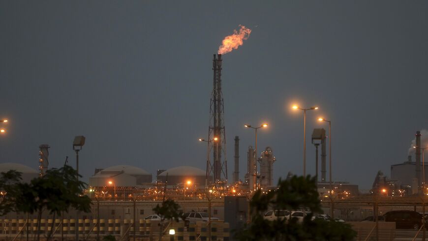 Lights illuminate a phosphate processing plant as a flame burns from a chimney in Saudi Arabia. 