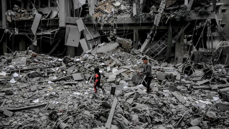Palestinians walk amid the rubble of houses destroyed by Israeli bombardment in Gaza City on March 3, 2024, amid the ongoing conflict between Israel and the Hamas movement