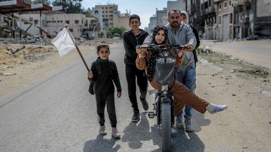 A girl holds a white flag as a displaced Palestinian family walks in Gaza City, in the territory's north where aid workers say the humanitarian situation is particularly acute