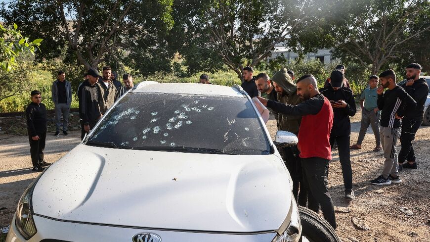 Palestinians check a bullet-riddled car following the raid by Israeli forces near Tubas in the occupied West Bank