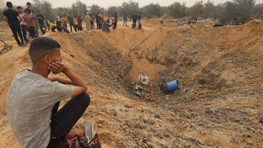 Palestinians examine a bomb crater Israeli bombardment in Rafah, the southern Gaza Strip 