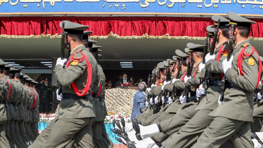 Soldiers march past Iran's President Ebrahim Raisi during a military parade in Tehran on April 17, 2024